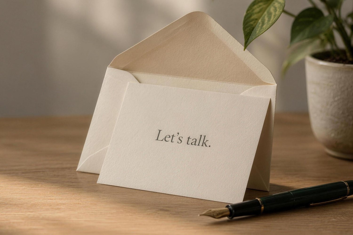 An opened envelope with a reply card that reads Let's talk, on a sunlit desk